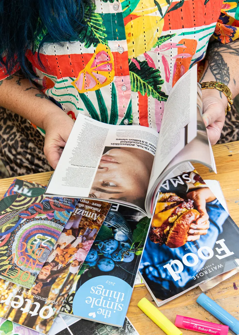 Someone leafing through a pile of magazines, looking for pictures and words to cut out.
